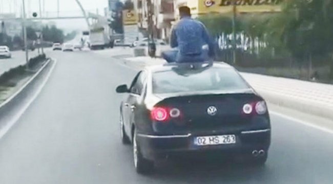 Otomobilin üstüne oturarak yolculuk yaptı